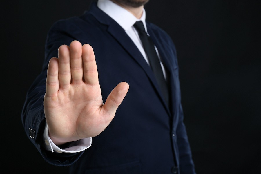 a man with his hand up declining a job interview