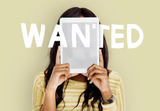 Girl looking at paper with wanted across the photo (company hiring recruitment vacancy)