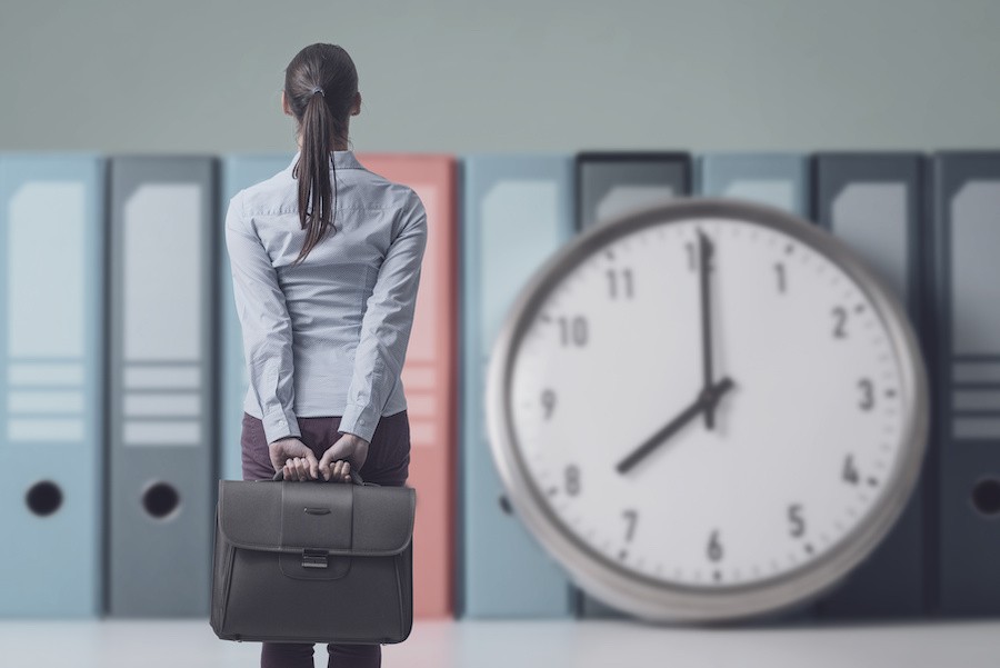woman facing a clock trying to figure out what to do while she waits to hear back from the recruiter