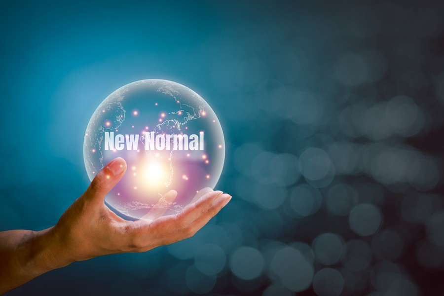 Someone holding a virtual ball with the words new normal 