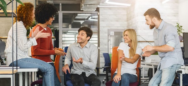 how being a good conversationalist helps in the workplace. Group of coworkers sitting together during a break conversing